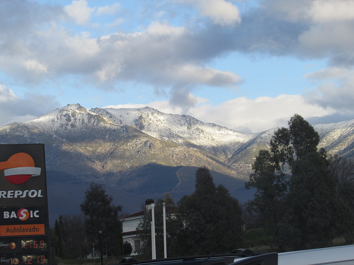Rótulo de una estación de servicio de Repsol con montañas nevadas al fondo